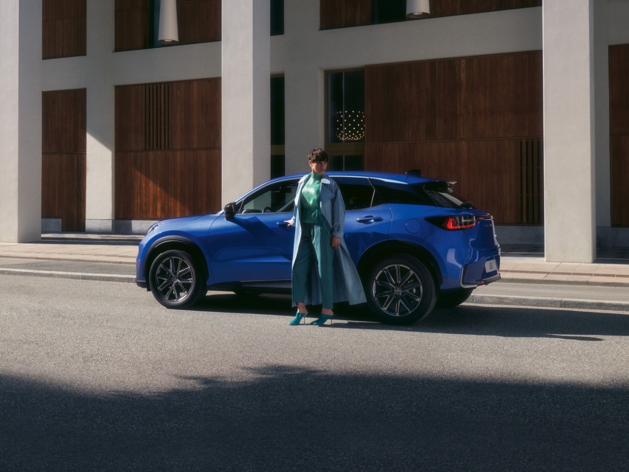 A person stood next to a Lexus LBX